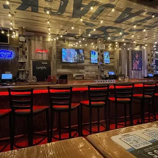 a bar with red chairs