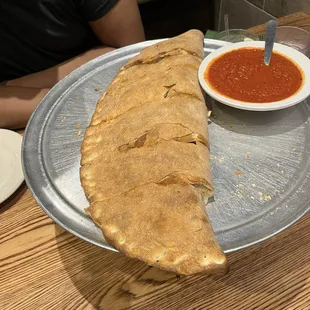 A large Classic Stromboli (pepperoni, ham, sausage, green peppers, mushroom) served with sauce