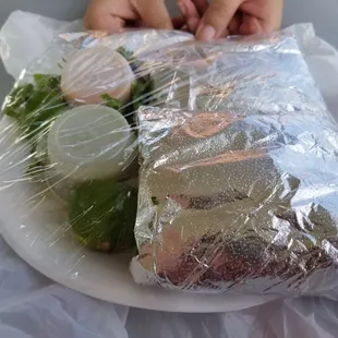 6 tacos neatly wrapped with extras on the side.
