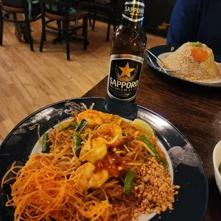 a plate of noodles and a bottle of beer