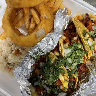 a plate of tacos and onion rings