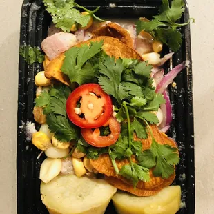 a black plastic container filled with vegetables