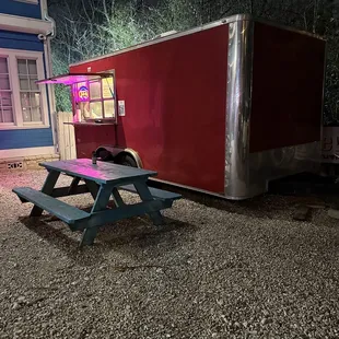 a picnic table in front of a trailer