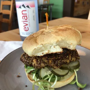 Vegan burger (quinoa patty, roasted pepper sauce, sunflower sprouts, tomato, pickle, hustlin&apos; honey mustard)