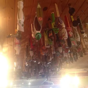 a bunch of beer bottles hanging from the ceiling