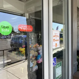 Signs advertising delivery through UberEats, DoorDash, and GrubHub.