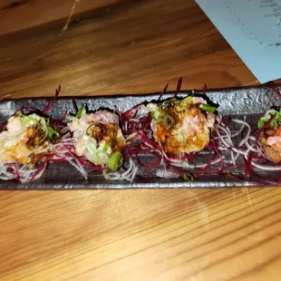 a long rectangular plate of food on a wooden table