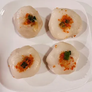 four scallops on a white plate