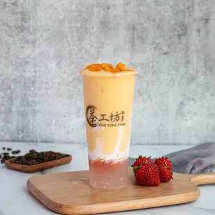 a glass of tea with a strawberries on a cutting board