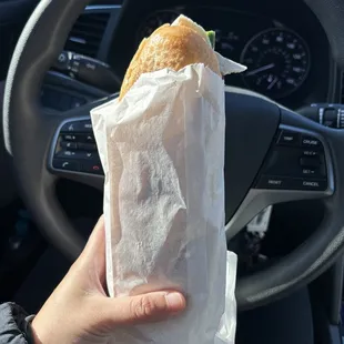 a person holding a sandwich in their hand