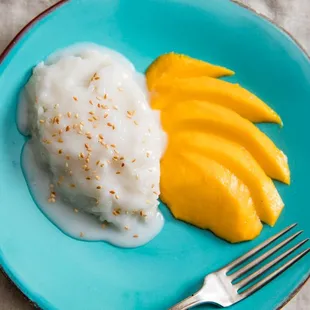 a plate of food with mangoes and yogurt