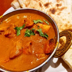 a bowl of curry and a flatbread