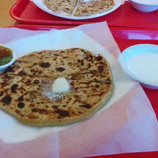 Freshly made Aloo paratha with a melting wad of unsalted butter and a side of masala curd . Goes very well with Mixed pickle .