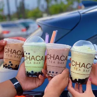 three people holding their drinks