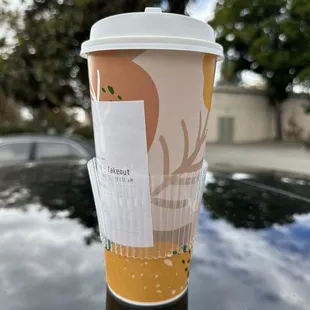 a cup of coffee on top of a car
