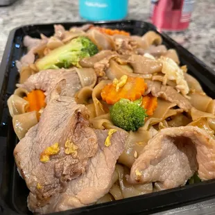 beef and noodles in a black container