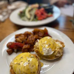 two eggs benedicts on a white plate