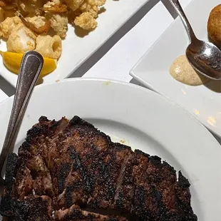 a plate of steak, potatoes, and other foods
