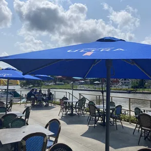 tables and chairs with blue umbrellas