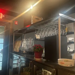 a bar with wine glasses on the shelves