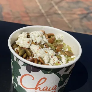 a cup of ice cream with nuts and cheese
