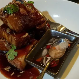 Crispy pork belly plum &amp; tamarillo sauce with cilantro fried shallot cucumber ribbon and nam place prig