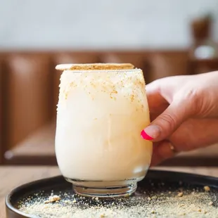 a hand holding a glass of chalet