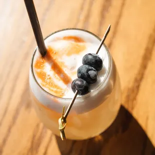 a drink with a straw and blueberries