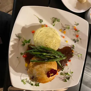 Beef Wellington, green beans, bread, and mashed potatoes