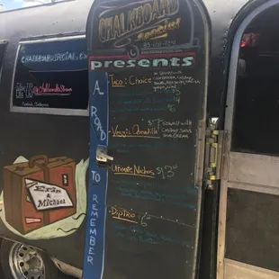 a chalkboard menu on the side of a food truck
