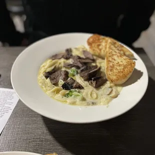 a plate of pasta with meat and vegetables