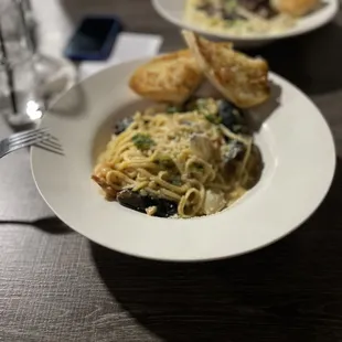 a plate of spaghetti with mushrooms and broccoli