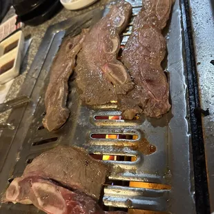 steaks being cooked on a grill