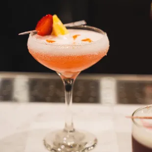 a cocktail with a strawberry garnish