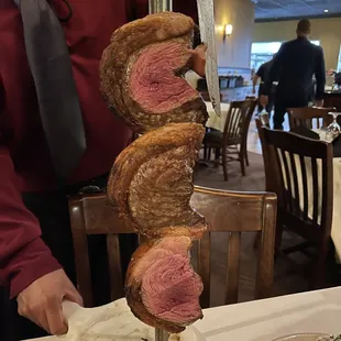 a man holding a rack of steaks