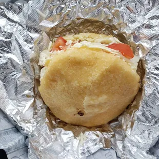 Full size arepas with shredded chicken, tomatoes, onions and of course, cheese