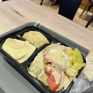 Base of vegetables with fish and hummus, baba ghannouj, yellow peppers, and tomato as the toppings