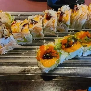 a platter of sushi rolls with various toppings