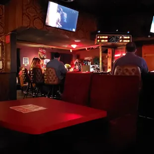 people sitting at a bar watching tv