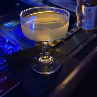 a cocktail in a coupe glass on a bar