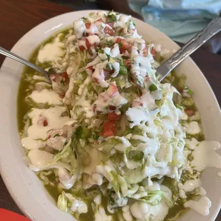 Smothered burrito with steak, rice and beans and cheese topped with a spicy green sauce more cheese and pico, lettuce and sour cream.