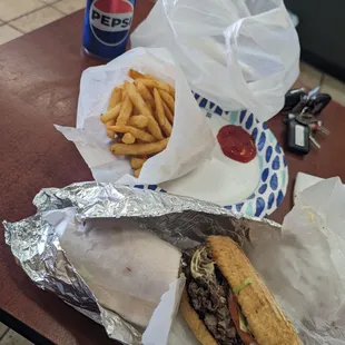 Cheese steak, can of Pepsi, fries.