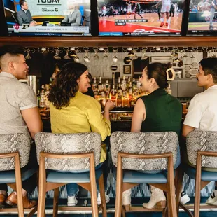 three people sitting at the bar