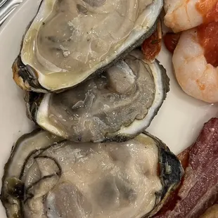 a plate of oysters, bacon, and shrimp