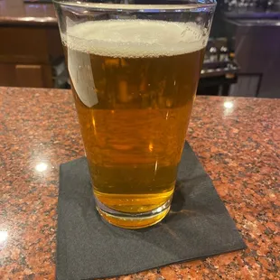 a glass of beer on a coaster
