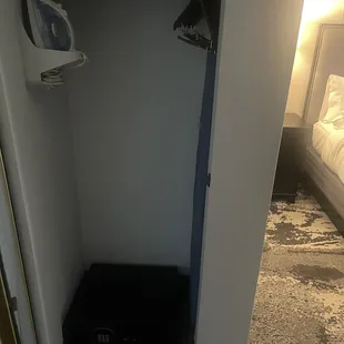 Inside of closest...ironing board,iron, clothes hangers and a safe to store valuables.