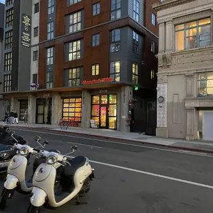 a row of scooters parked on a city street