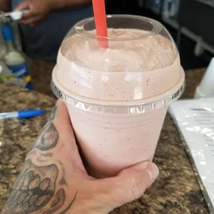 a hand holding a smoothie