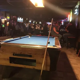 a pool table with a pool cue