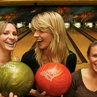 a group of women holding bowling balls